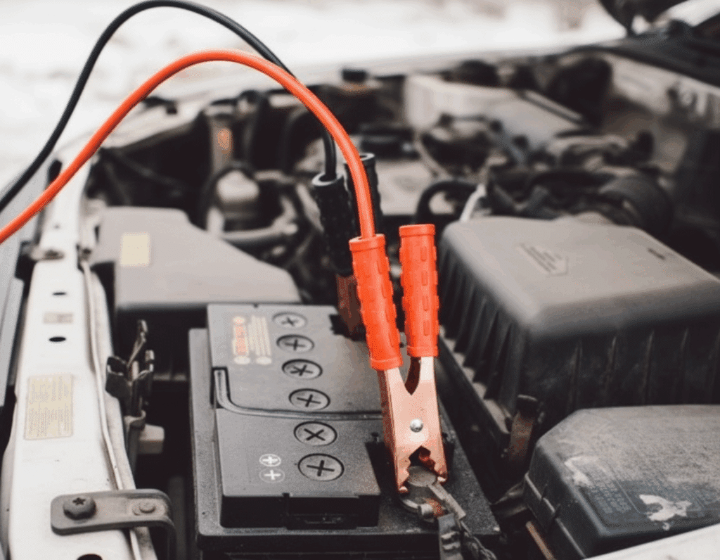 Pinzas conectadas a la batería de un vehículo para intentar arrancarlo, una escena habitual cuando el coche no arranca