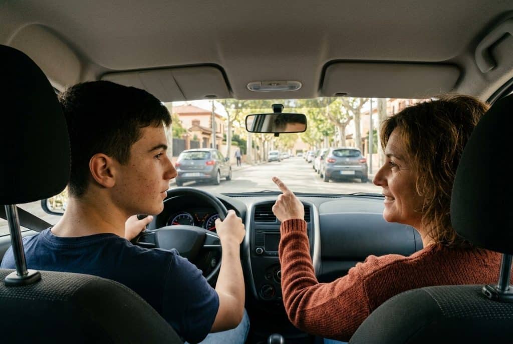 Conducción acompañada: joven de 17 años al volante con su madre de acompañante en el asiento del copiloto, el sistema de la nueva directiva europea del carnet de conducir